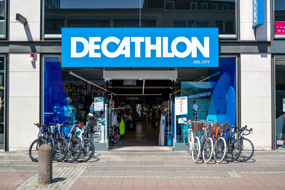 Logo di Decathlon con un negozio in background